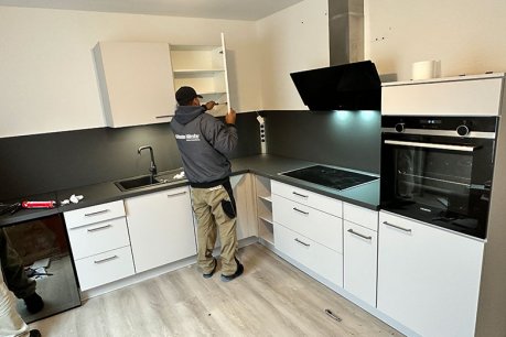 Küchenmonteur verschraubt eine Küchentür